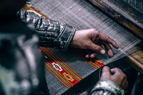 Person, sewing beautiful and colorful patterns on the cloth