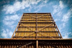 Low angle shot of the industrial building, in light, in Duisburg, Germany, under the blue sky with white clouds