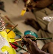 Artist, painting with yellow paint, on the brush