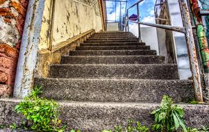 Stairs of the old building, with the railing and colorful plants
