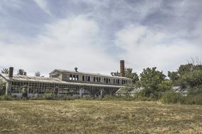 distant view of an old abandoned factory in a field