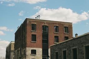 Colorful brickwork buildings, in light and shadow, under the blue sky with white clouds