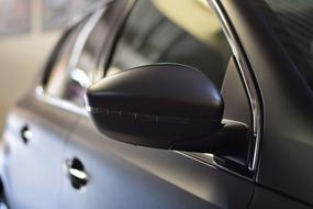 Close-up of the mirror of a car, with the foil carwrap, in light and shadow