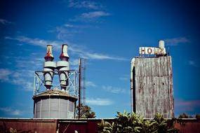 Roof of the old, abandoned, rusty factory, at blue sky with white clouds on background