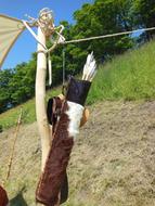 Arrows in the brown and white Medieval leather arrow quiver, near the green plants