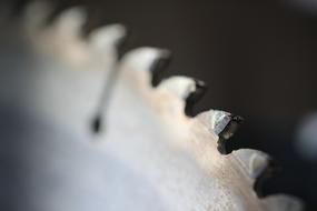 Close-up of the colorful metal saw, at blurred background