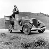 black and white, a man sitting on a retro ford car