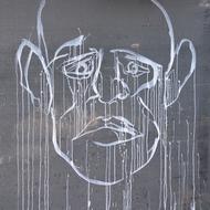 White graffiti with the human head, on the grey wall