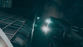 Shiny buildings, with the lights, under the sky, with the clouds, at the night