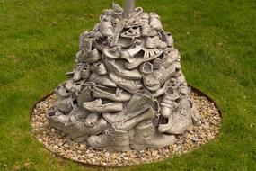 pile of shoes as a sculpture on green grass