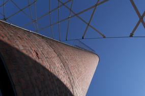 Low angle shot of a brick chimney, at beautiful blue sky on background