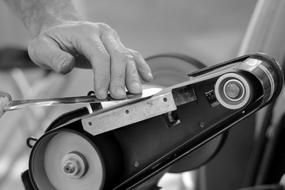 man sharpening knife on sharpener