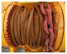 Colorful rope and chain on the metal winch of the machine