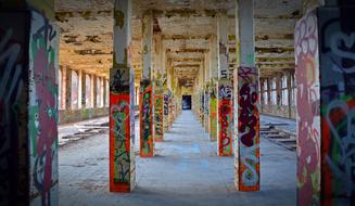 Old factory, with the pillars, and colorful and beautiful graffities, and light through the windows