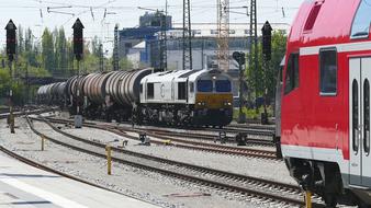 Trains on the railway, among the green trees and buildings