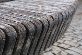 Close-up of the round wooden bench, on the pavement with colorful leaves