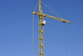 High, yellow tower at blue sky on background