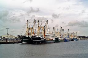 Colorful fishing boats on the beautiful waterscape, under the cloudy sky in Texel, Netherlands