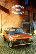 classic brown ford near an old brick building