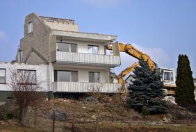 Demolition of a house on a hill with trees