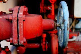 Close-up of the red and turquoise metal pump of the machine