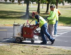 workers mark the pedestrian crossing on the road