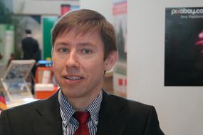 a man in a suit on the background of an exhibition stand