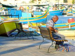 fisherman with tackle on a bench on the waterfront