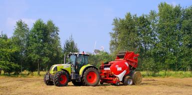 tractor with round baler in the field