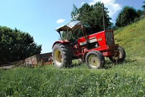 Red Tractor parked on green grass