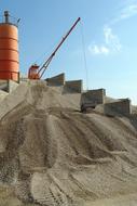 Landscape with the machinery, on a site, at blue sky with white clouds on background