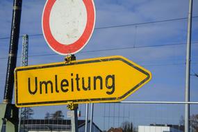 direction road sign near fence