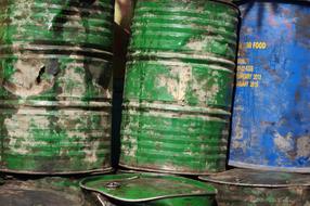 Old, green and blue barrels with holes