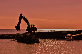 Digger Working at Sunset