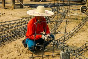 Construction worker man in hat, on the sand in Thailand