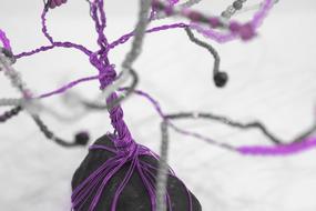 Close-up of the beautiful tree made of the stone and purple and metallic wires