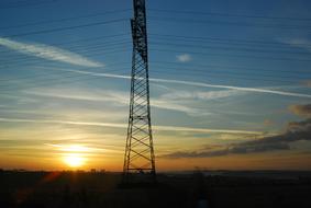 Landscape with the power poles, at beautiful and colorful sunset in the sky with clouds