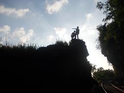 people on the hill above the railroad