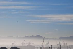 Beautiful landscape with the cranes in fog and mountains on background