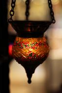 Beautiful and colorful, patterned Asian candle, with the light, at blurred background, in Turkey