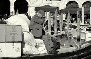 black and white, old man in a working boat in Venice, Italy