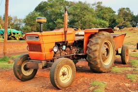 Orange Tractor with carriage on Farm