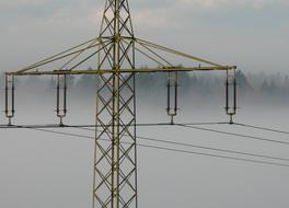 strommast in dense fog on the background of the forest