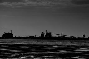 Black and white photo with the industrial buildings, on the shore