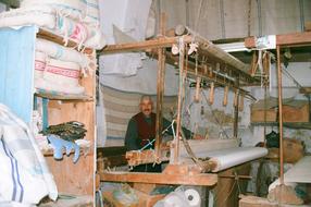 Smiling weaver, with the loom in Tunisia