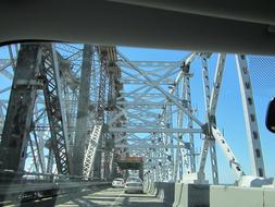 Bridge with the cars, in light, above the Mississippi River in New Orleans, USA, under the blue sky