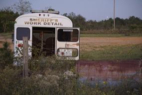 Old police bus, on the colorful field, in the evening