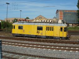 yellow industrial carriage on rails at the train station