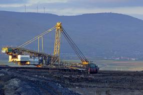 Giant machine for coal mining, on the beautiful landscape with the mountains