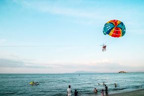 people are paragliding over the ocean